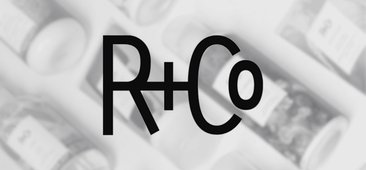 R+Co logo over blurred background of hair products.